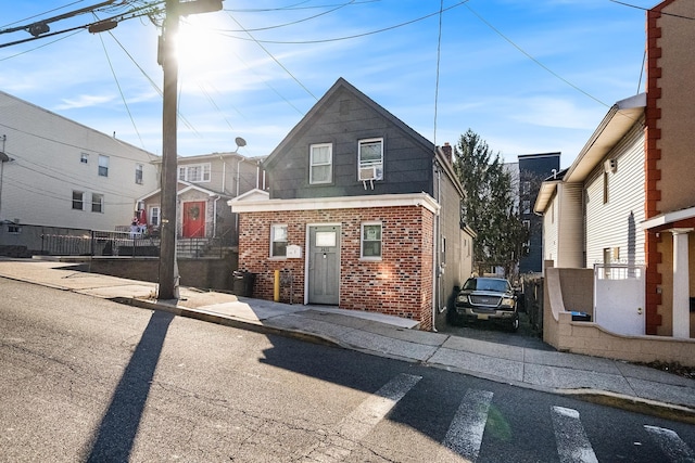 view of front facade featuring fence and brick siding