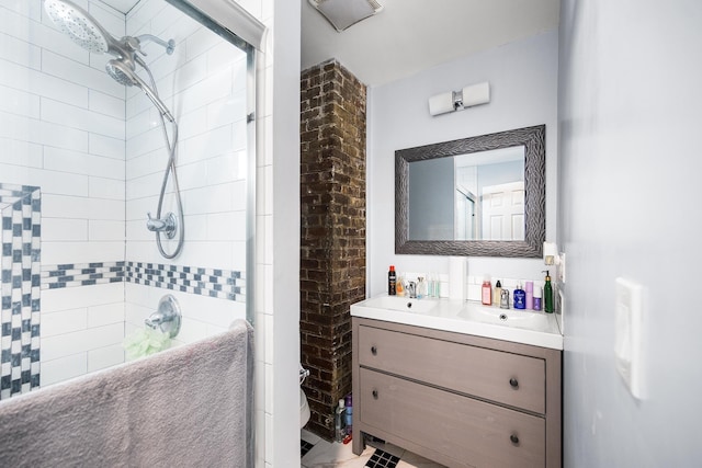 bathroom featuring visible vents, tiled shower, and vanity