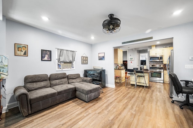 living area with light wood finished floors, baseboards, and recessed lighting