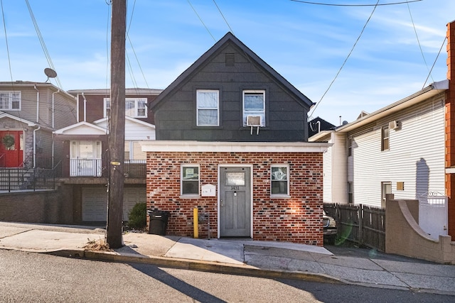 view of front facade featuring fence and brick siding