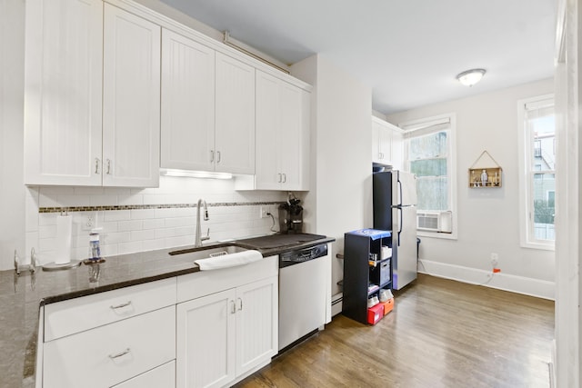 kitchen featuring white cabinets, dishwasher, dark stone countertops, sink, and fridge