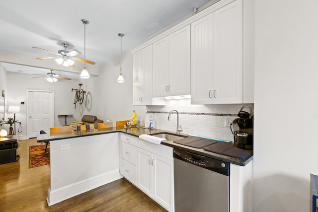 kitchen with stainless steel dishwasher, white cabinets, kitchen peninsula, and sink