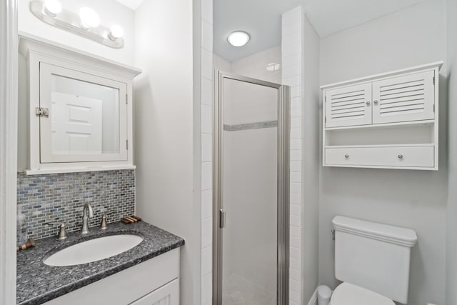 bathroom with toilet, decorative backsplash, walk in shower, and vanity