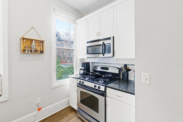 kitchen with white cabinets, a healthy amount of sunlight, stainless steel appliances, and hardwood / wood-style floors