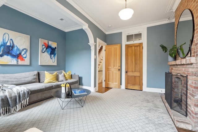 254 4th St, Jersey City, NJ 07302 - carpeted living room with ornate columns, a brick fireplace, baseboards, ornamental molding, and arched walkways