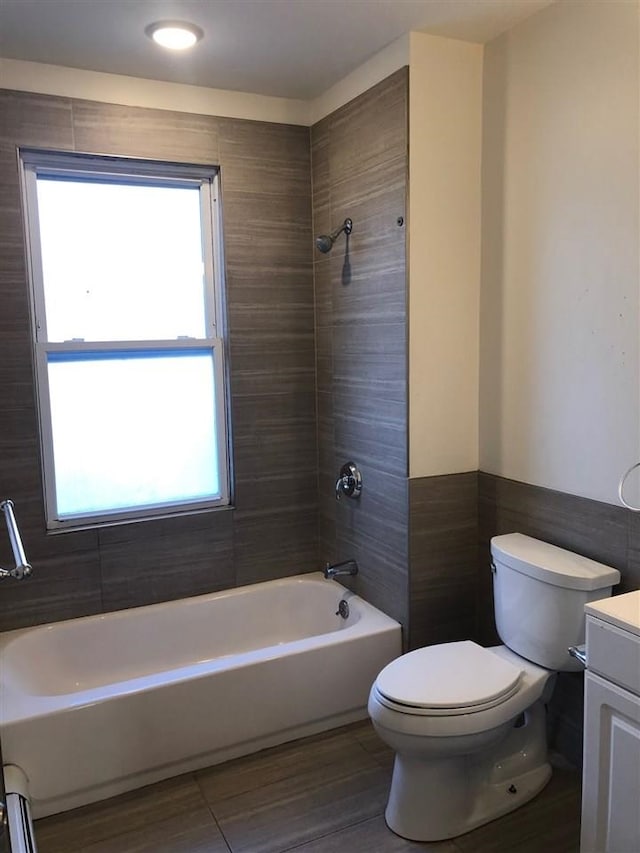 549 Pavonia Ave Unit 1 & 2, Jersey City, NJ 07306 - bathroom featuring toilet, vanity, plenty of natural light, shower / bathtub combination, and tile walls