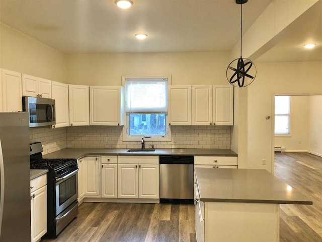 549 Pavonia Ave Unit 1 & 2, Jersey City, NJ 07306 - kitchen featuring appliances with stainless steel finishes, a sink, dark countertops, dark wood-type flooring, and recessed lighting