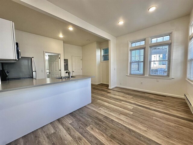 549 Pavonia Ave Unit 1 & 2, Jersey City, NJ 07306 - kitchen featuring a peninsula, a sink, dark wood-style floors, stainless steel microwave, and white cabinetry