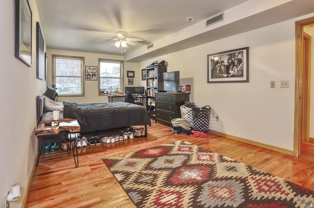 bedroom featuring wood finished floors, visible vents, and baseboards