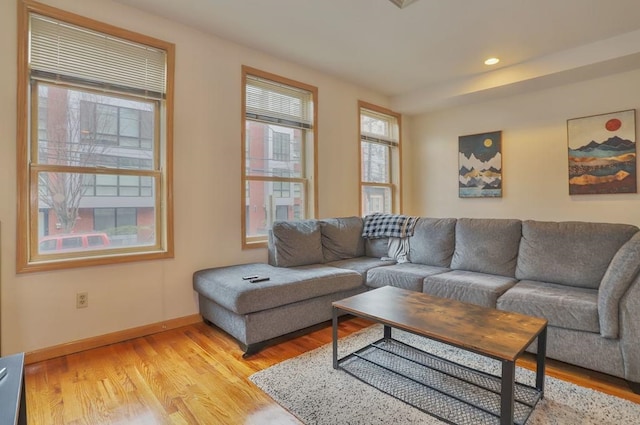 living area featuring recessed lighting, baseboards, and light wood finished floors