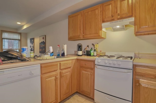 kitchen with white appliances, light tile patterned flooring, a sink, light countertops, and under cabinet range hood