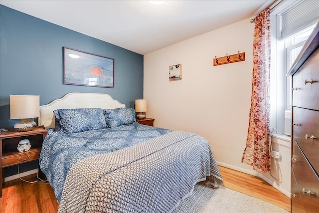 bedroom featuring wood finished floors and baseboards