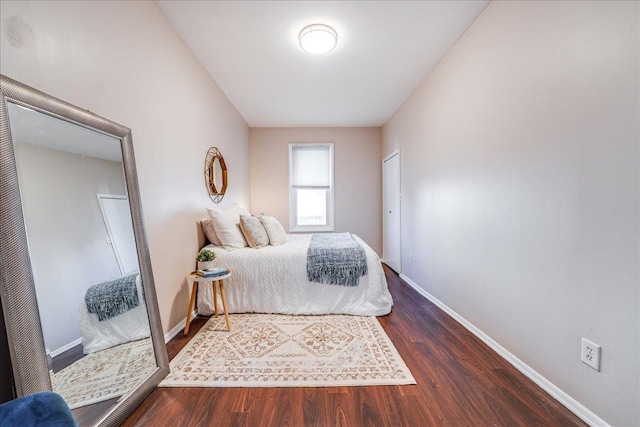 bedroom with baseboards and wood finished floors