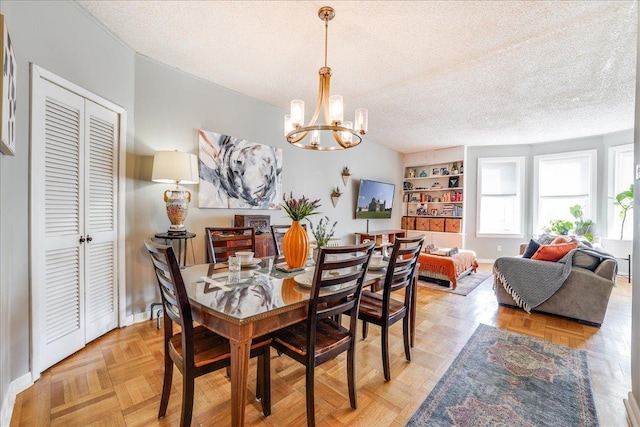 dining room with a notable chandelier, baseboards, and a textured ceiling