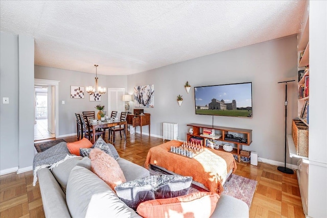 living area with an inviting chandelier, radiator heating unit, baseboards, and a textured ceiling