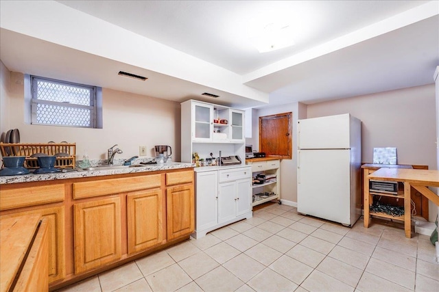 kitchen featuring open shelves, a sink, light tile patterned flooring, and freestanding refrigerator