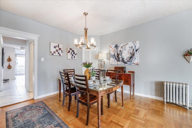 dining space featuring baseboards, a textured ceiling, an inviting chandelier, and radiator heating unit