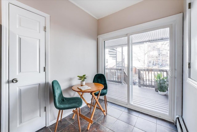 living area featuring tile patterned floors, ornamental molding, baseboards, and a baseboard radiator