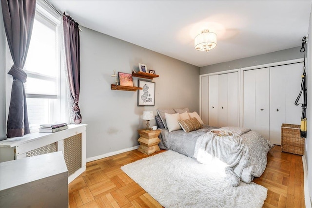 bedroom with baseboards and two closets