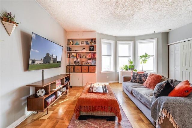 living area featuring a textured ceiling and baseboards