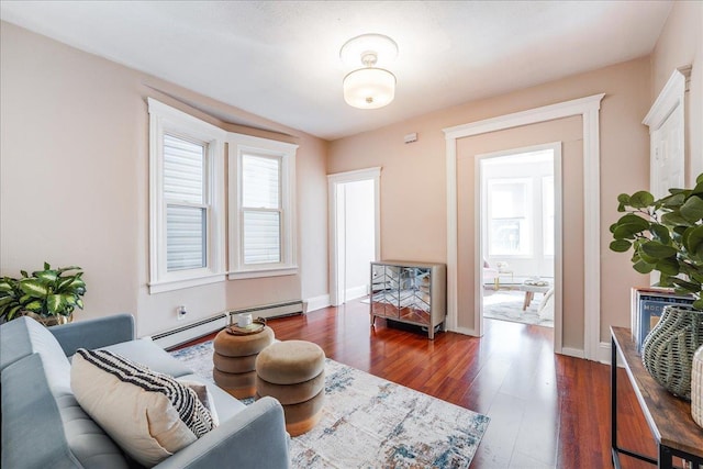 living area featuring a baseboard radiator, baseboards, and dark wood-style flooring