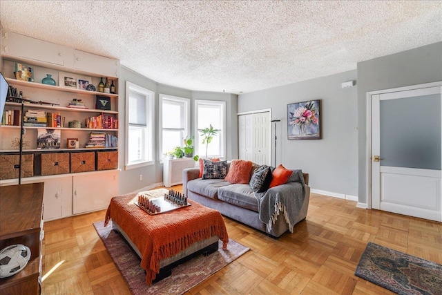 living area featuring baseboards and a textured ceiling