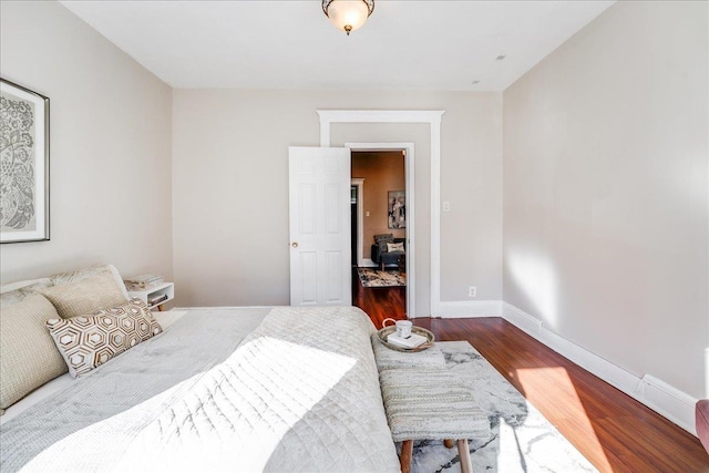 bedroom with baseboards and dark wood-style flooring