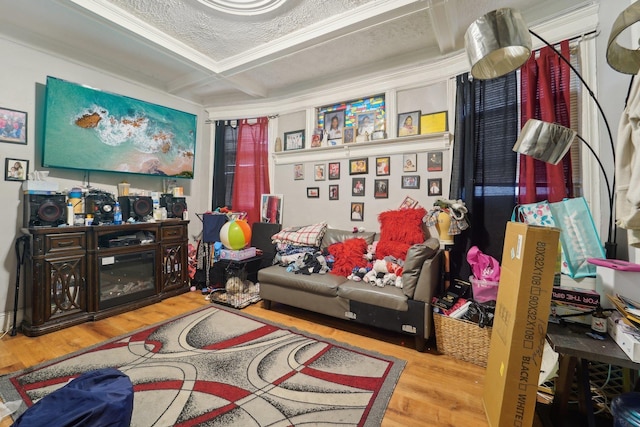 living area featuring wood-type flooring, a textured ceiling, ornamental molding, coffered ceiling, and beamed ceiling