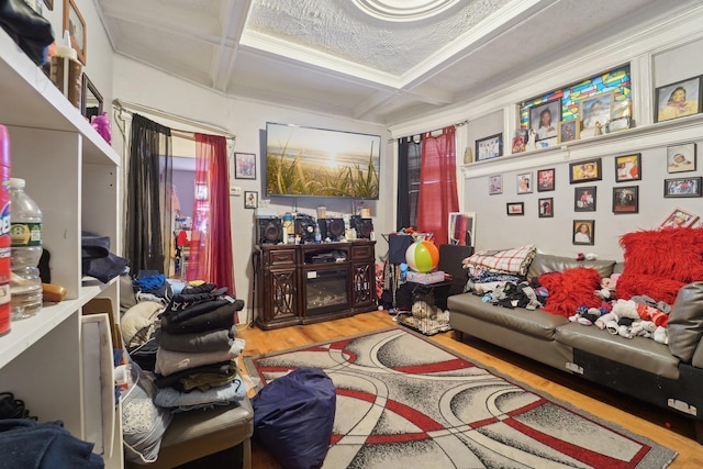 living area featuring coffered ceiling, beam ceiling, hardwood / wood-style floors, and crown molding