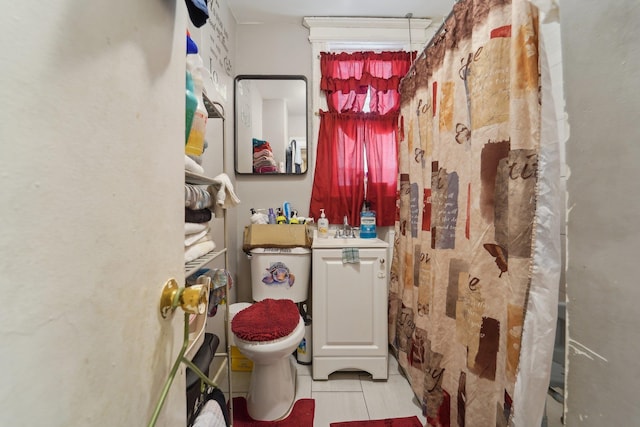 bathroom with sink, toilet, and tile patterned flooring