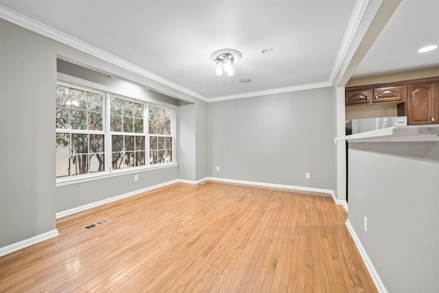 unfurnished living room featuring visible vents, light wood-style flooring, baseboards, and ornamental molding