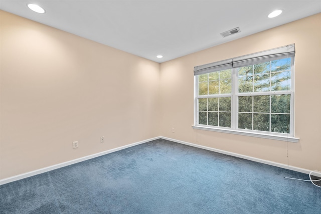 empty room with recessed lighting, visible vents, baseboards, and dark carpet