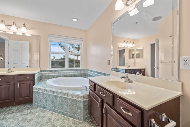 full bathroom with tile patterned flooring, two vanities, a garden tub, and a sink