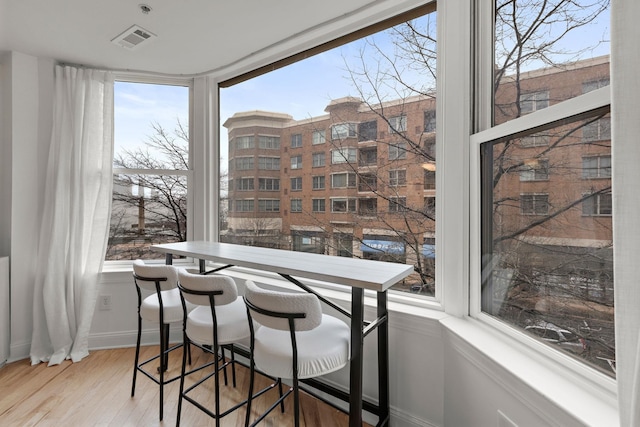 dining space with visible vents, baseboards, and wood finished floors