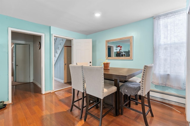 dining room featuring baseboards, baseboard heating, and wood finished floors