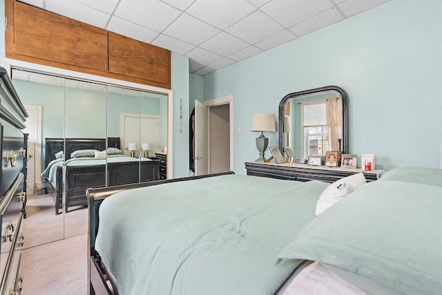 bedroom featuring carpet floors, a closet, and a paneled ceiling