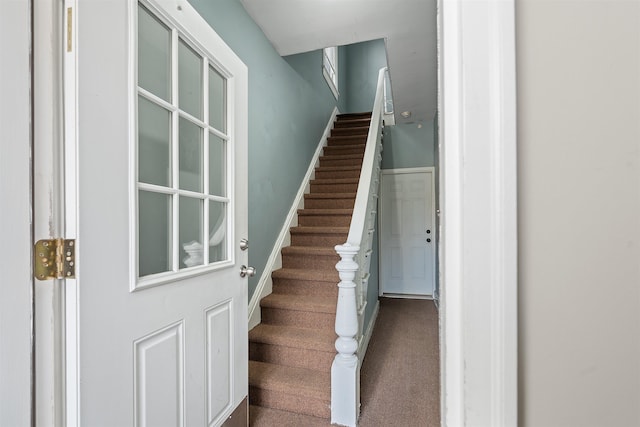 staircase with carpet floors and baseboards