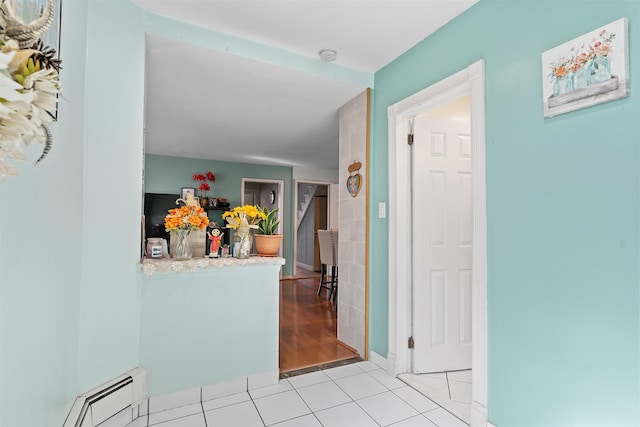 foyer featuring baseboards, baseboard heating, and light tile patterned flooring