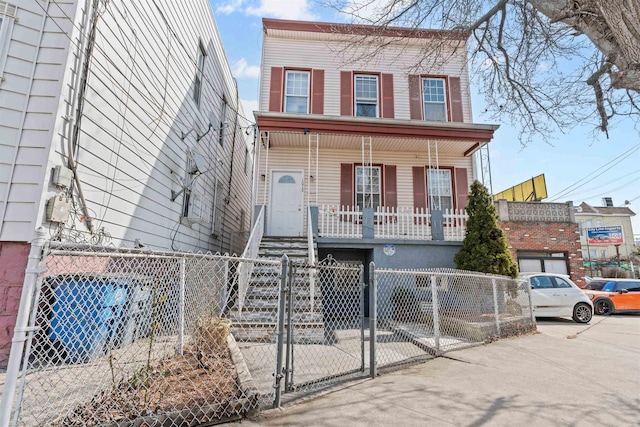 view of front of home featuring a fenced front yard, covered porch, and a gate