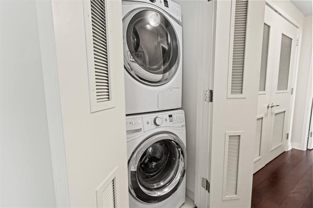 1200 Avenue At Port Imperial Unit 301, Weehawken, NJ 07086 - washroom with stacked washer / dryer and dark wood finished floors