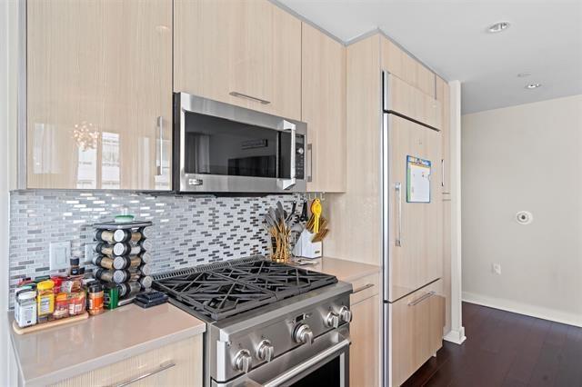 1200 Avenue At Port Imperial Unit 301, Weehawken, NJ 07086 - kitchen with high quality appliances, light brown cabinets, light countertops, backsplash, and modern cabinets
