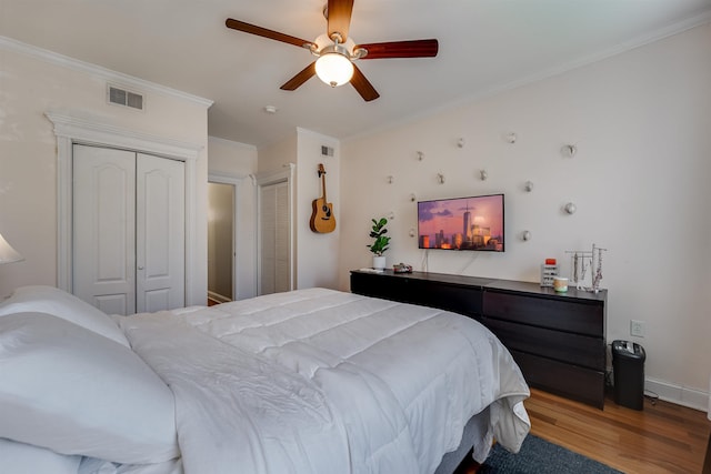 380 7th St Unit 2A, Jersey City, NJ 07302 - bedroom featuring wood finished floors, ornamental molding, a ceiling fan, and multiple closets