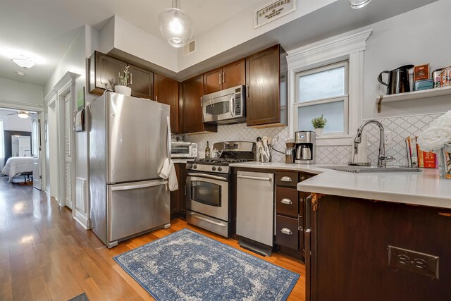380 7th St Unit 2A, Jersey City, NJ 07302 - kitchen with appliances with stainless steel finishes, light wood-style floors, tasteful backsplash, and light countertops
