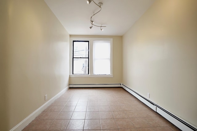 6034 Palisade Ave, West New York, NJ 07093 - empty room featuring a baseboard radiator, light tile patterned flooring, and rail lighting