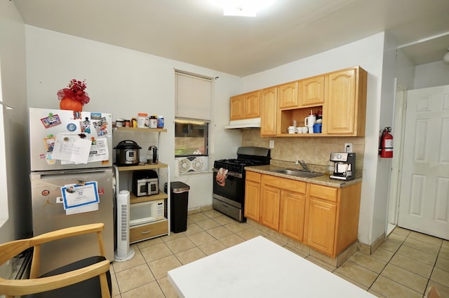6034 Palisade Ave, West New York, NJ 07093 - kitchen featuring stainless steel gas range oven, freestanding refrigerator, under cabinet range hood, backsplash, and light tile patterned floors