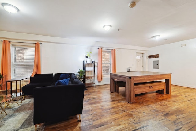 rec room featuring electric panel, baseboards, and wood finished floors