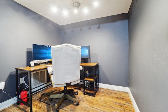 home office with track lighting, wood finished floors, and baseboards