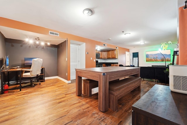 dining room featuring light wood finished floors, visible vents, and baseboards