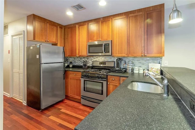 508 Grand St Unit 1L, Hoboken, NJ 07030 - kitchen with appliances with stainless steel finishes, dark countertops, a sink, dark wood-type flooring, and recessed lighting