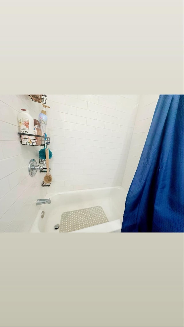 bathroom with shower / bath combination with curtain